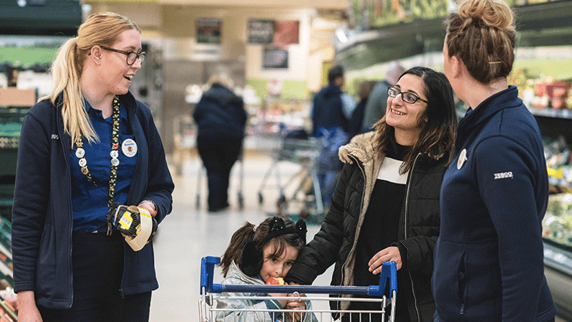 Tesco staff member talking to customers